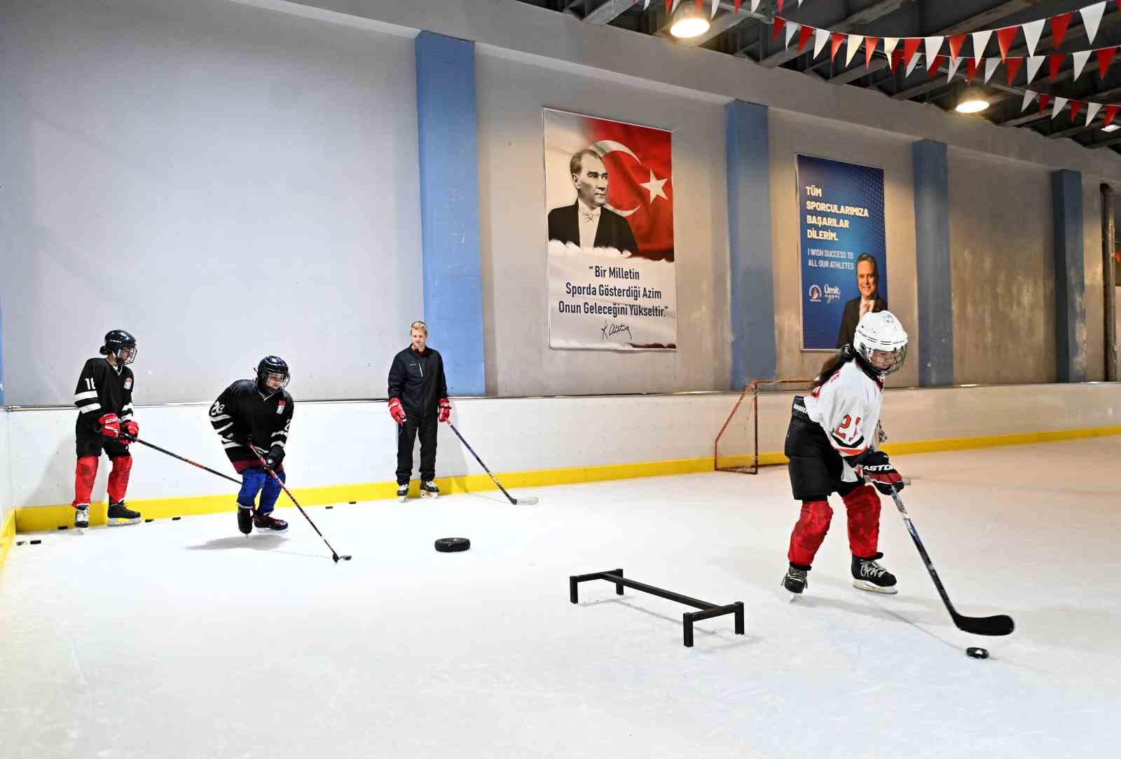 Buz hokeyi gelişim kampında genç sporcular buz pistinde antrenman yaparken