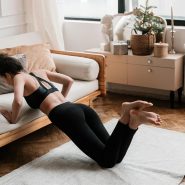 A woman stretches on a mat in a stylish living room, promoting a healthy lifestyle.