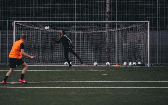 a couple of people on a field with a soccer ball