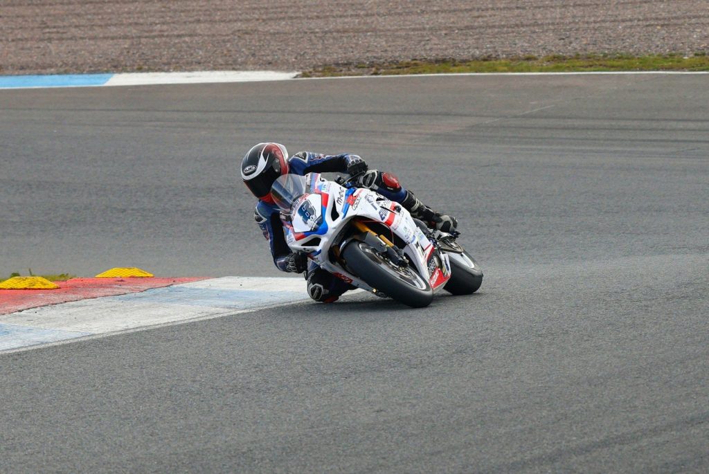 Motorcyclist leans into a sharp turn on a race track