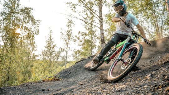 a man riding a bike down a dirt road