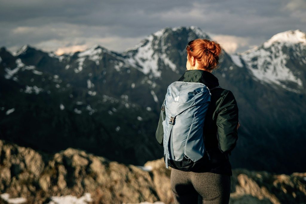 a woman standing on top of a snow covered mountain