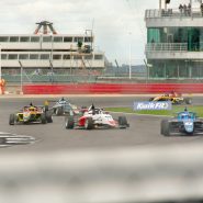 a group of racing cars driving down a race track