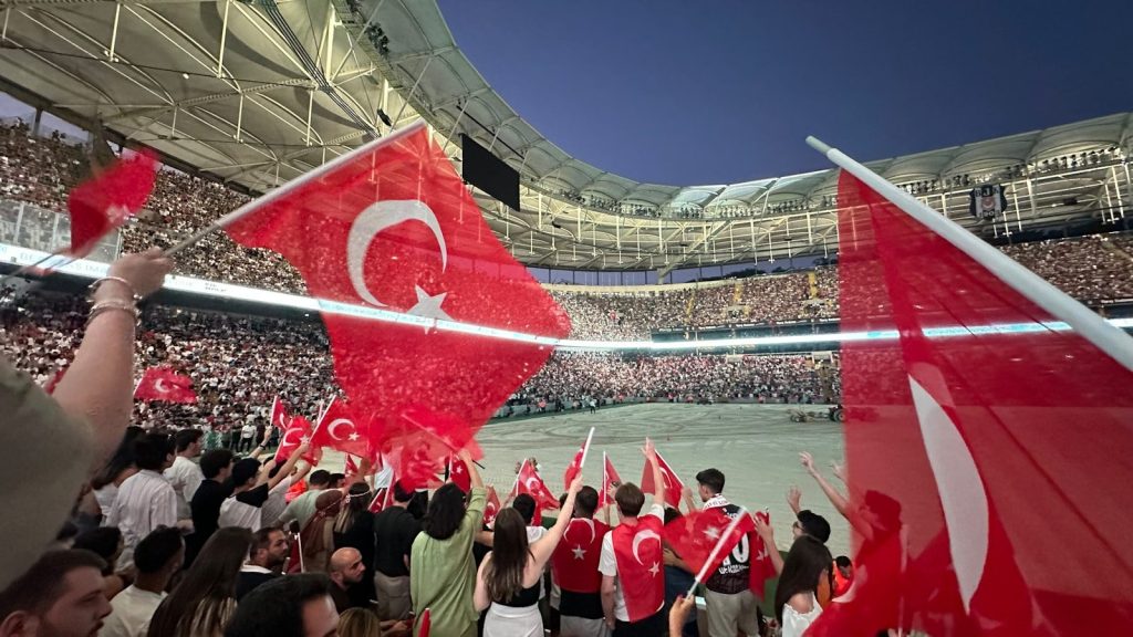 A group of people holding flags in a stadium