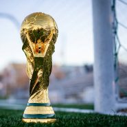 a golden soccer trophy sitting on top of a field