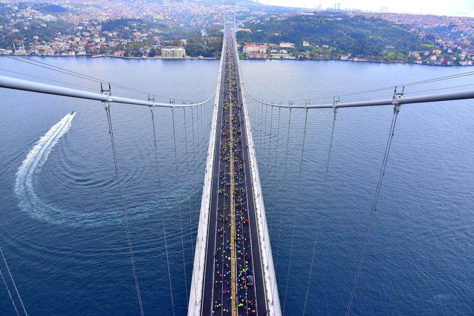 Aerial view of the Bosphorus Bridge in Istanbul filled with marathon runners on a clear day.
