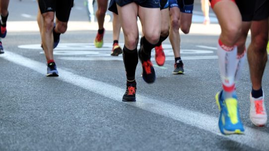 people running on gray asphalt road during daytime