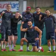 Trabzonspor futbolcuları yağmurlu antrenmanda gülümseyerek toplu poz verirken