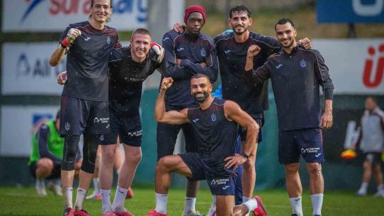 Trabzonspor futbolcuları yağmurlu antrenmanda gülümseyerek toplu poz verirken