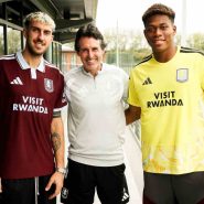 Aston Villa'nın bordo ve sarı formalarını giyen iki futbolcu teknik direktörle birlikte tesiste poz verirken