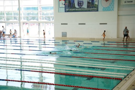 Kapalı yüzme havuzunda sporcular kulvarlarda yüzerken