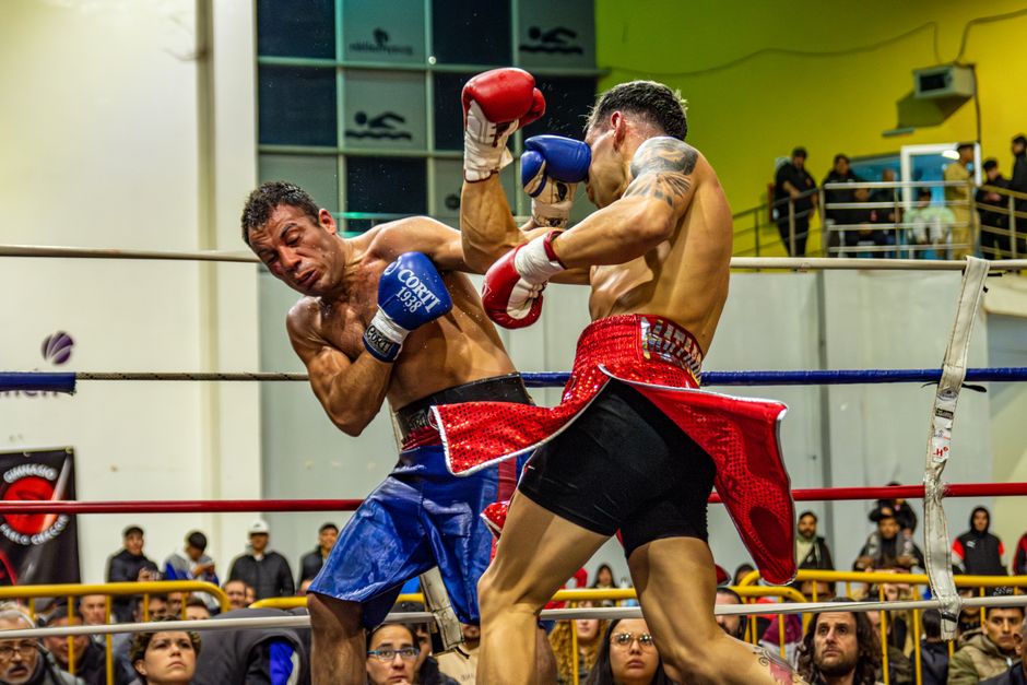 Dynamic capture of two boxers in a heated championship fight indoors.