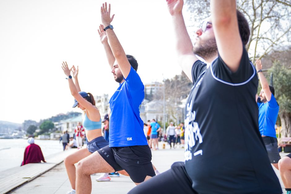 Group performing yoga outdoors along the scenic waterfront in İstanbul, Türkiye.