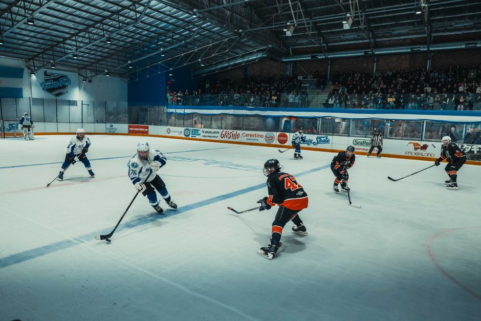 Dynamic ice hockey match captured in Buenos Aires with players in action on the ice rink.