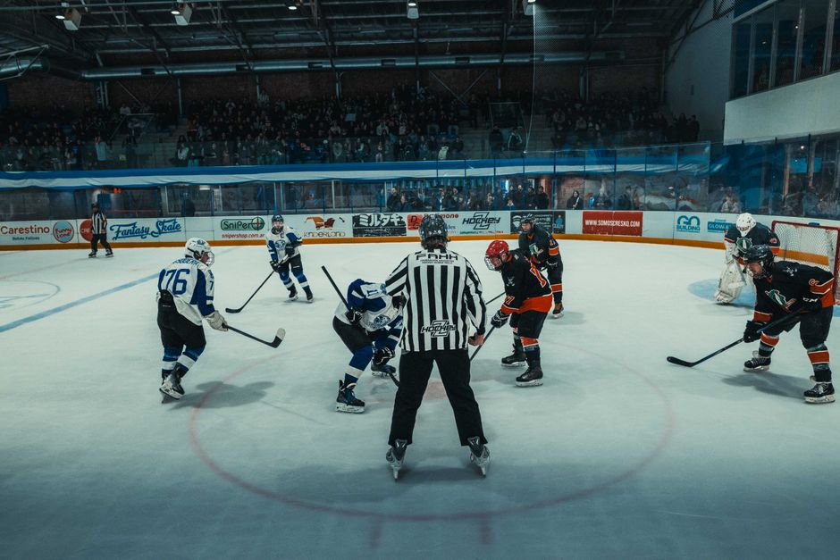 Exciting ice hockey face-off at an indoor arena in Buenos Aires with teams in action and full audience.