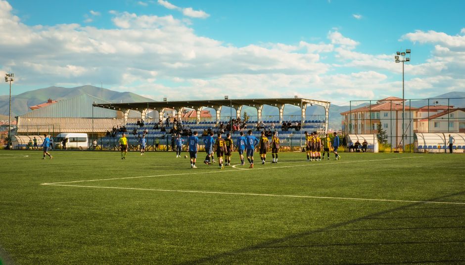 An outdoor soccer game with teams playing on a grass field in Malatya, Türkiye.