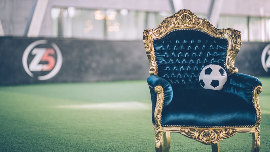 Elegant blue armchair with a soccer ball on an indoor field in Aix-en-Provence.
